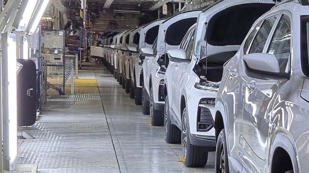 Imagen de archivo de una línea de producción automotriz con varios vehículos en fabricación.