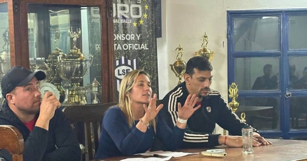 Personas vinculadas al futsal durante una reunión, junto a trofeos de la Liga Sanluiseña.