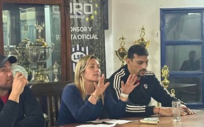Personas vinculadas al futsal durante una reunión, junto a trofeos de la Liga Sanluiseña.