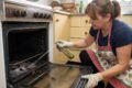 Imagen ilustrativa de una persona limpiando un horno donde se observan cucarachas y aplicando un producto de control de plagas.