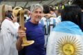 Jorge Messi sostiene un trofeo rodeado de hinchas durante una celebración vinculada a Lionel Messi.