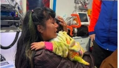 Una mujer sostiene a una niña en brazos dentro de un vehículo de asistencia médica tras el hallazgo en San Luis.