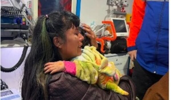 Una mujer sostiene a una niña en brazos dentro de un vehículo de asistencia médica tras el hallazgo en San Luis.