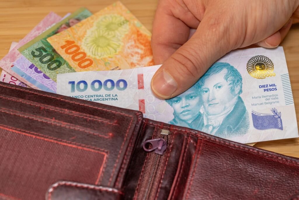 Imagen contextual de billetes argentinos en una billetera, vinculada al crédito y la situación financiera.