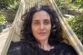 Retrato de Julieta Díaz sentada en una hamaca, en un espacio al aire libre.