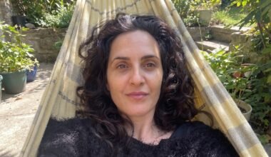 Retrato de Julieta Díaz sentada en una hamaca, en un espacio al aire libre.
