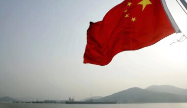 Imagen de archivo contextual de la bandera de China ondeando frente a un paisaje montañoso.