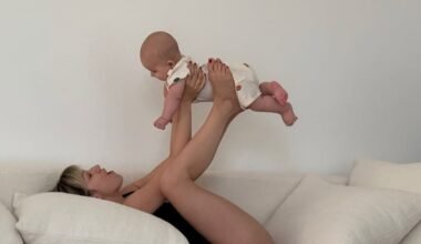 Úrsula Corberó juega con su hijo Dante en un sofá, levantándolo suavemente con las piernas.