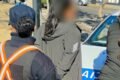 Mujer con el rostro difuminado junto a personal policial y un móvil durante el operativo en San Luis.