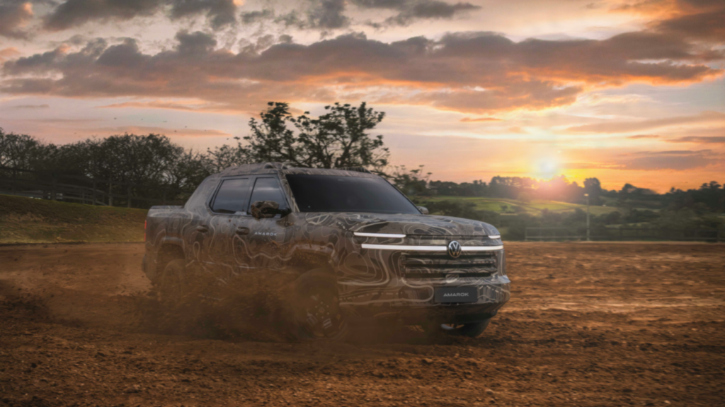 La futura Volkswagen Amarok camuflada circula por un terreno de tierra durante su presentación pública.