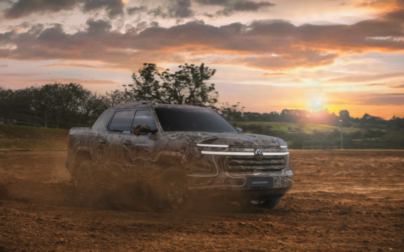 La futura Volkswagen Amarok camuflada circula por un terreno de tierra durante su presentación pública.