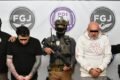 Los dos imputados permanecen bajo custodia junto a agentes de seguridad durante una presentación oficial del caso.