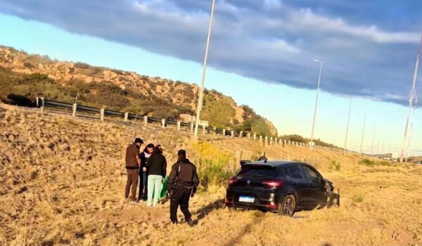 Uno de los vehículos involucrados en el choque aparece fuera de la autopista, junto a varias personas.