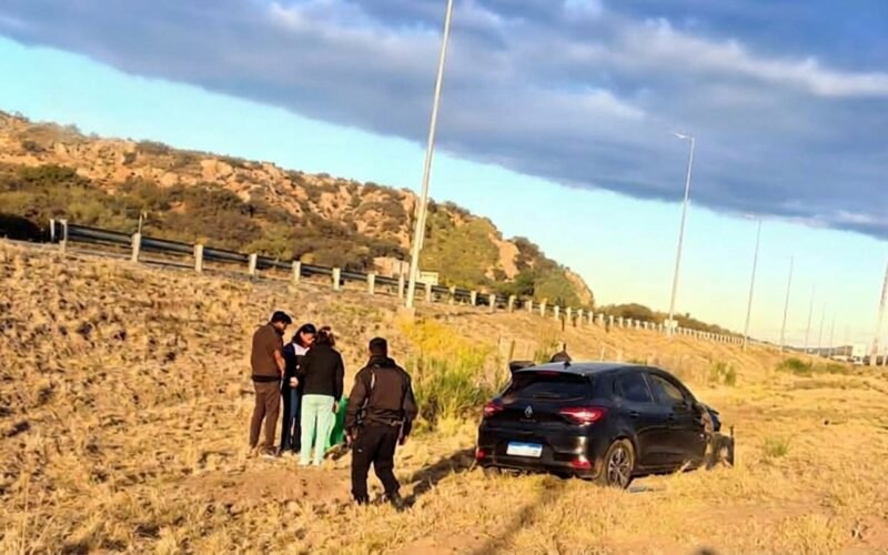 Uno de los vehículos involucrados en el choque aparece fuera de la autopista, junto a varias personas.