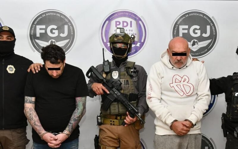 Los dos imputados son escoltados por agentes frente a insignias de la Fiscalía y la Policía de Investigación.