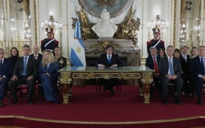 Javier Milei encabeza una cadena nacional sobre la causa Malvinas, sentado junto a funcionarios en un salón oficial.
