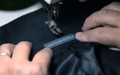 Imagen de archivo de una máquina de coser trabajando sobre una prenda con la etiqueta “Made in Argentina”.