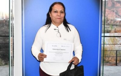 Estela Figueroa sostiene un certificado frente a una ventana.