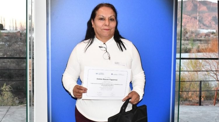 Estela Figueroa sostiene un certificado frente a una ventana.