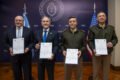 Funcionarios civiles y militares sostienen documentos durante un acto oficial del Ministerio de Defensa argentino relacionado con la incorporación de vehículos blindados Stryker.