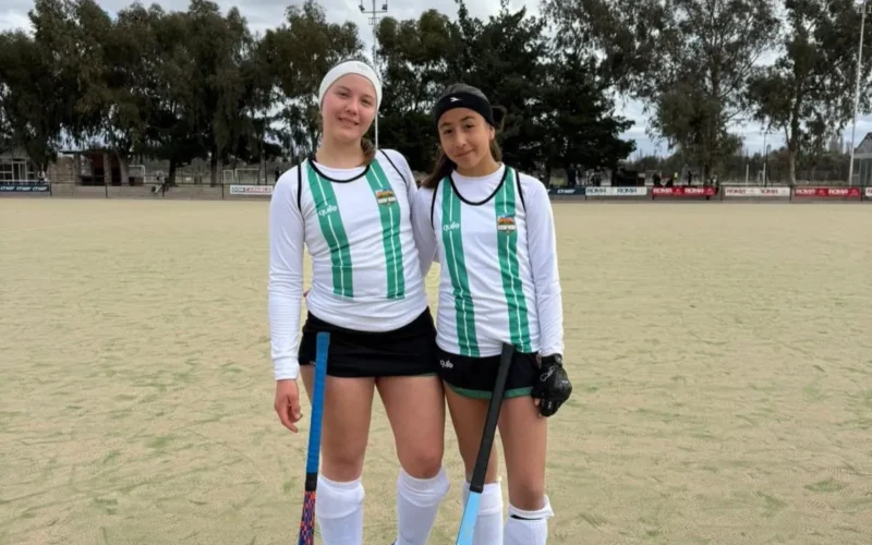 Sigrid Sackewitz y Lara Ferreyra, jugadoras del seleccionado puntano Sub 16, posan con sus palos en una cancha de hockey.