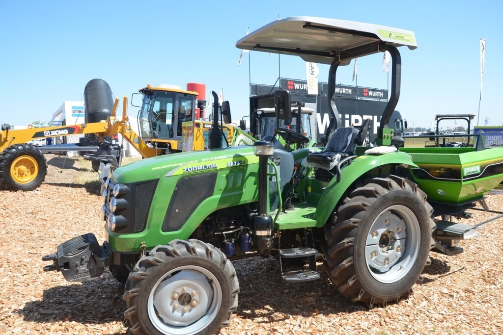 Tractor agrícola exhibido junto a otros equipos y maquinaria.