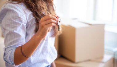 Imagen ilustrativa de una joven sosteniendo las llaves de una vivienda junto a cajas de mudanza.