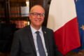 Giuseppe Valditara, ministro de Educación y Mérito de Italia, retratado junto a las banderas de Italia y la Unión Europea.