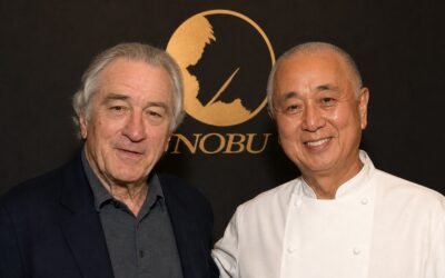 Robert De Niro y el chef Nobu Matsuhisa posan juntos frente al logo de Nobu.