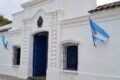 Imagen contextual de la Casa Histórica de la Independencia en San Miguel de Tucumán, con banderas argentinas en su fachada.