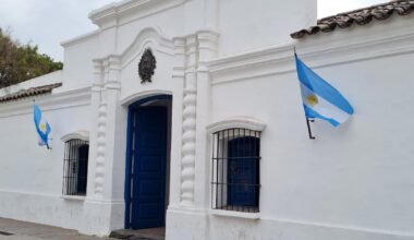 Imagen contextual de la Casa Histórica de la Independencia en San Miguel de Tucumán, con banderas argentinas en su fachada.