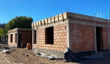Obra en construcción de viviendas del programa Tenemos Futuro, con paredes de ladrillo y estructuras de hormigón.
