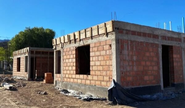 Obra en construcción de viviendas del programa Tenemos Futuro, con paredes de ladrillo y estructuras de hormigón.
