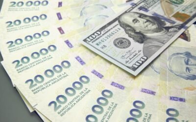 Imagen contextual de billetes argentinos de 20.000 pesos junto a billetes de 100 dólares.