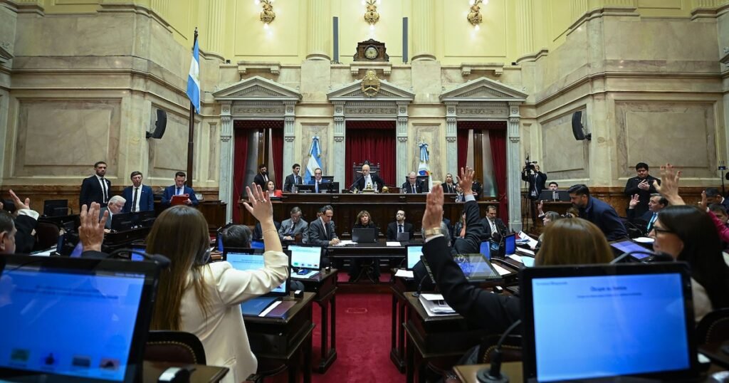 El recinto del Senado argentino durante una votación, con legisladores levantando la mano.