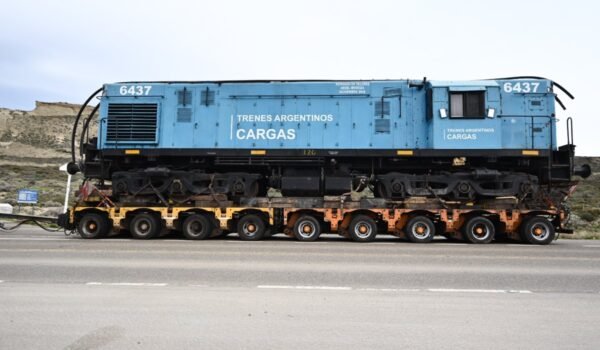 La locomotora 6437 de Trenes Argentinos Cargas es trasladada sobre un carretón por una ruta patagónica.