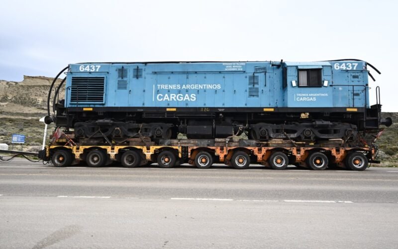 La locomotora 6437 de Trenes Argentinos Cargas es trasladada sobre un carretón por una ruta patagónica.