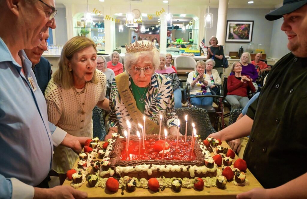 Imagen contextual de Anna Decanini en la celebración de su cumpleaños, rodeada de familiares y una torta.