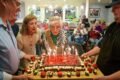Imagen contextual de Anna Decanini en la celebración de su cumpleaños, rodeada de familiares y una torta.
