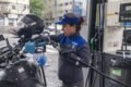 Imagen contextual de una trabajadora de YPF cargando combustible en una estación de servicio.