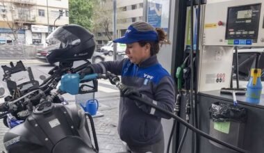 Imagen contextual de una trabajadora de YPF cargando combustible en una estación de servicio.