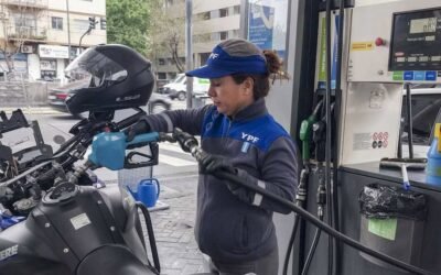 Imagen contextual de una trabajadora de YPF cargando combustible en una estación de servicio.