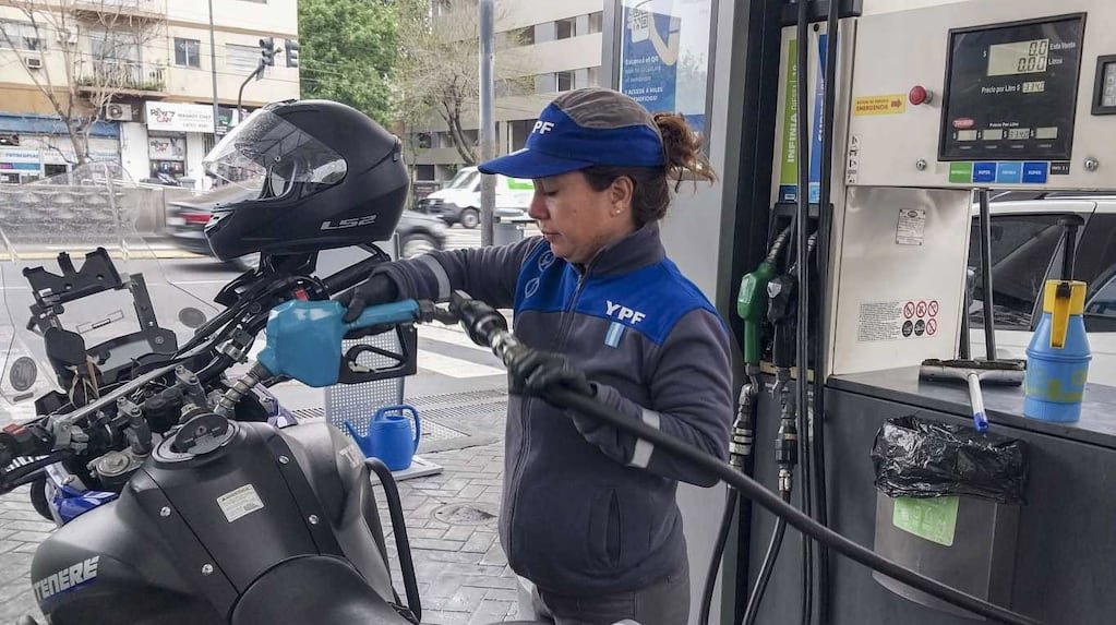 Imagen contextual de una trabajadora de YPF cargando combustible en una estación de servicio.