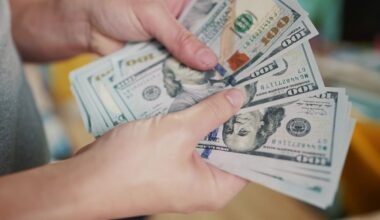 Imagen contextual de una persona contando billetes de dólares estadounidenses.