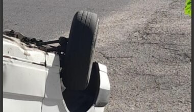 Un automóvil blanco volcado sobre el pavimento tras el choque en el barrio San Martín.