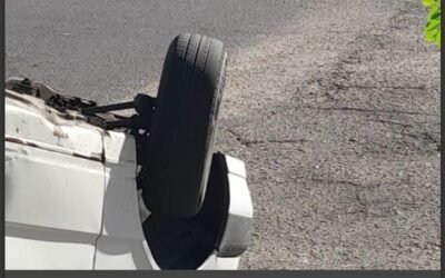 Un automóvil blanco volcado sobre el pavimento tras el choque en el barrio San Martín.