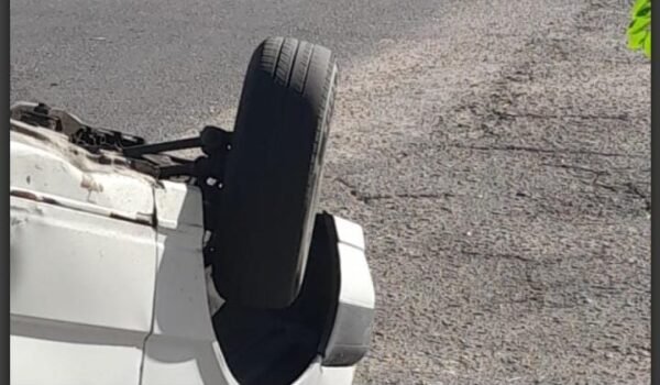 Un automóvil blanco volcado sobre el pavimento tras el choque en el barrio San Martín.