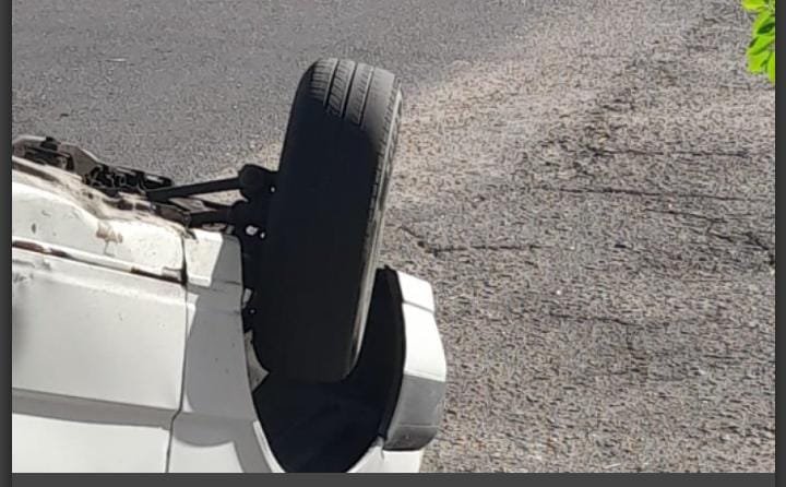 Un automóvil blanco volcado sobre el pavimento tras el choque en el barrio San Martín.