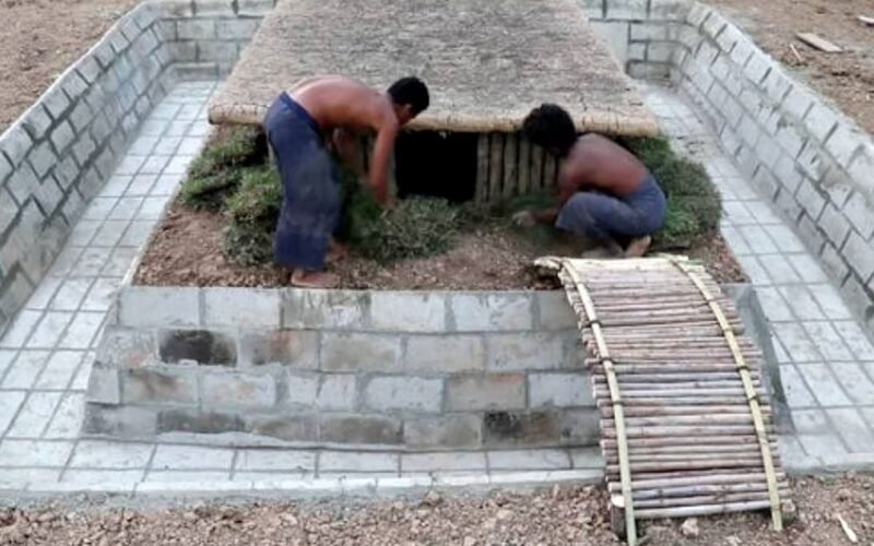 Dos personas trabajan en una vivienda semienterrada rodeada por una pileta en construcción.