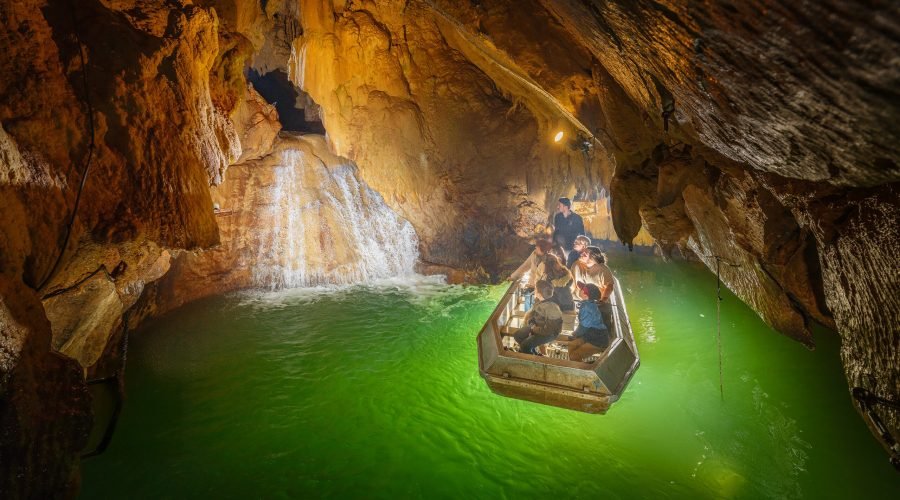 Visitantes recorren en barca la Rivière Souterraine de Labouïche, entre formaciones rocosas subterráneas.